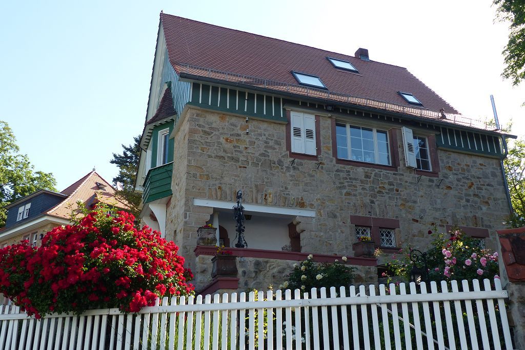 Seitenansicht eines Metzendorfgebäudes mit Sandsteinfassade und grünen Fensterläden