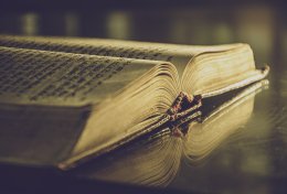 Aufgeschlagenes antikes Buch in dunklem Licht