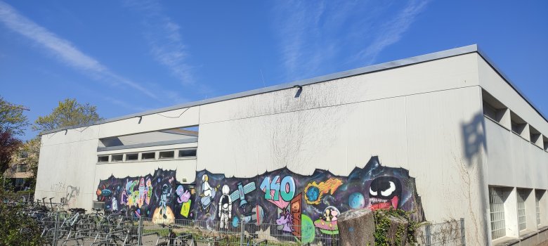 Außenansicht der Halle des Starkenburg Gymnasiums mit buntem Graffiti